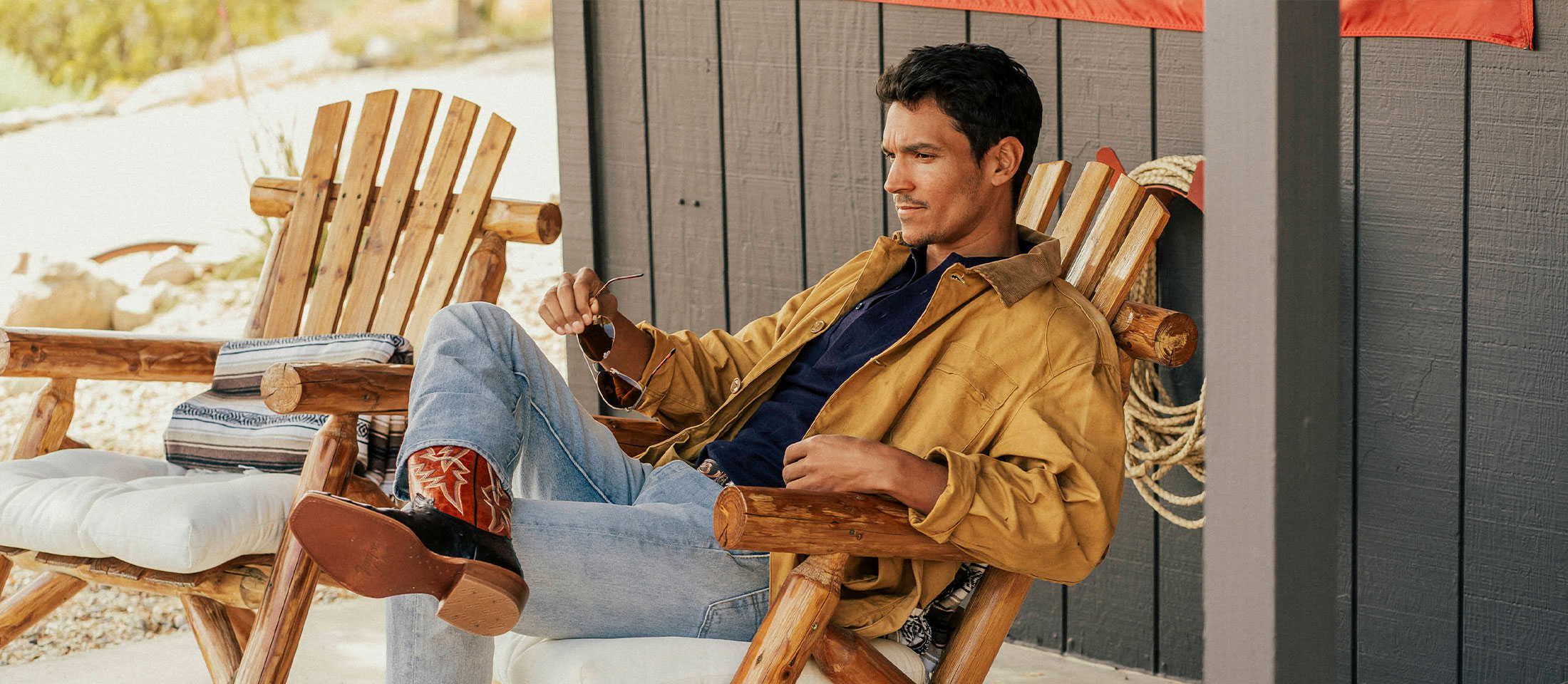 A man sitting on his porch wearing the Rylen 13" Full Quill western boots in brown